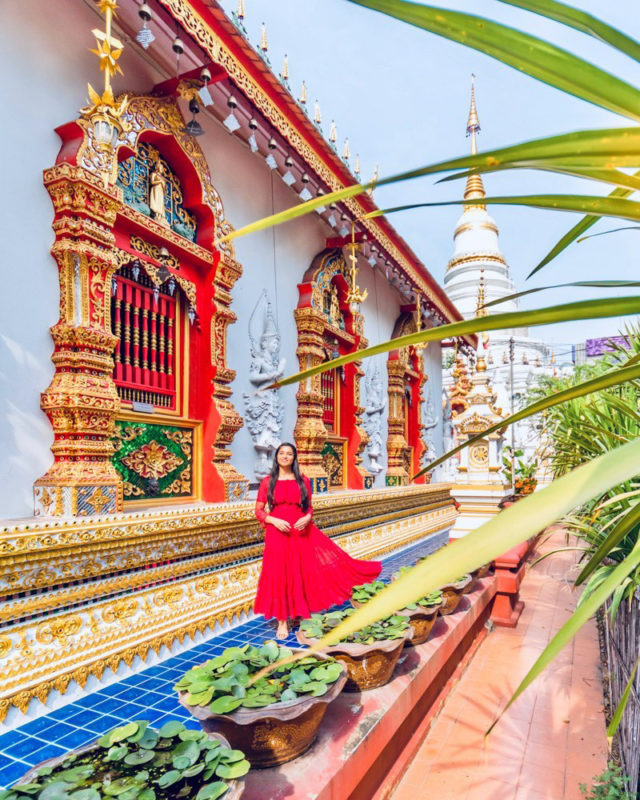 A girl in red dress standing in front of Wat Upakhut temple in Chiang Mai