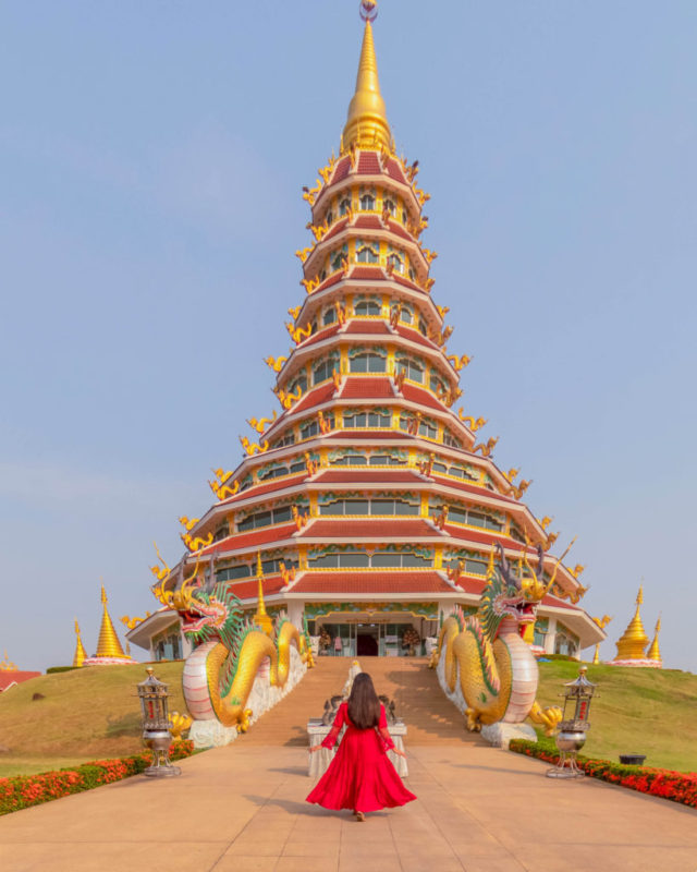 A girl in red dress standing in front of 9 tier pagoda
