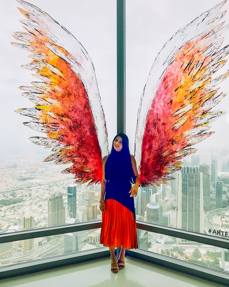 A girl posing with the wings at the top of Burj Khalifa