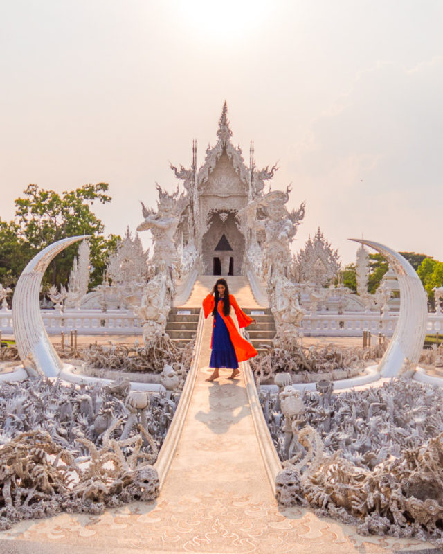 A girl standing at the bridge at white temple