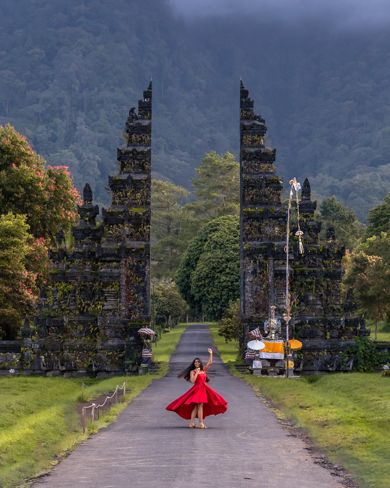 A girl in red dress posing against the backdrop of handara gate near wanagiri hidden hills
