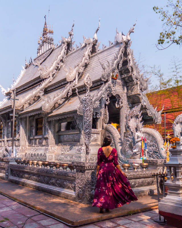 A girl standing in front of silver temple