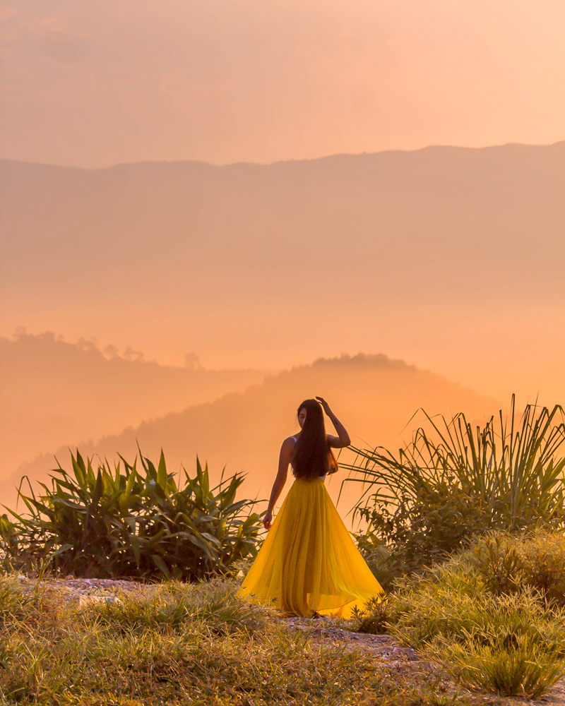 A girl in yellow skirt in a scenic sunrise setting
