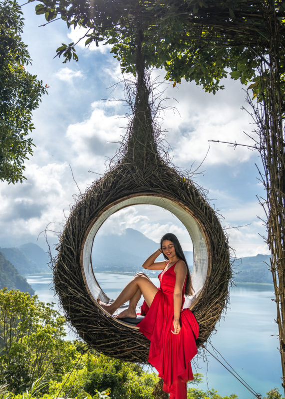 A girl in red dress sitting in a nest at wanagiri hidden hills
