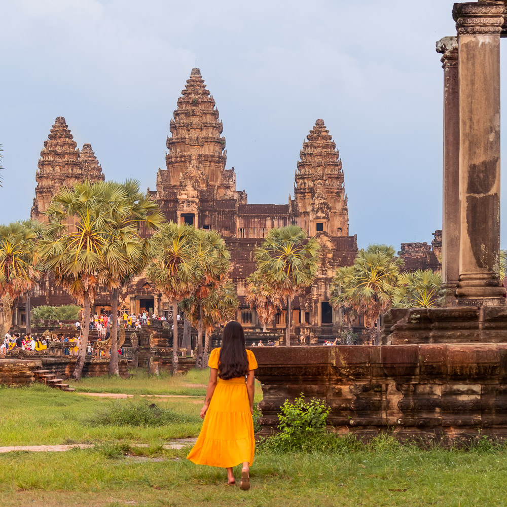A girl in yellow dress looking at Angkor Wat in Cambodia
