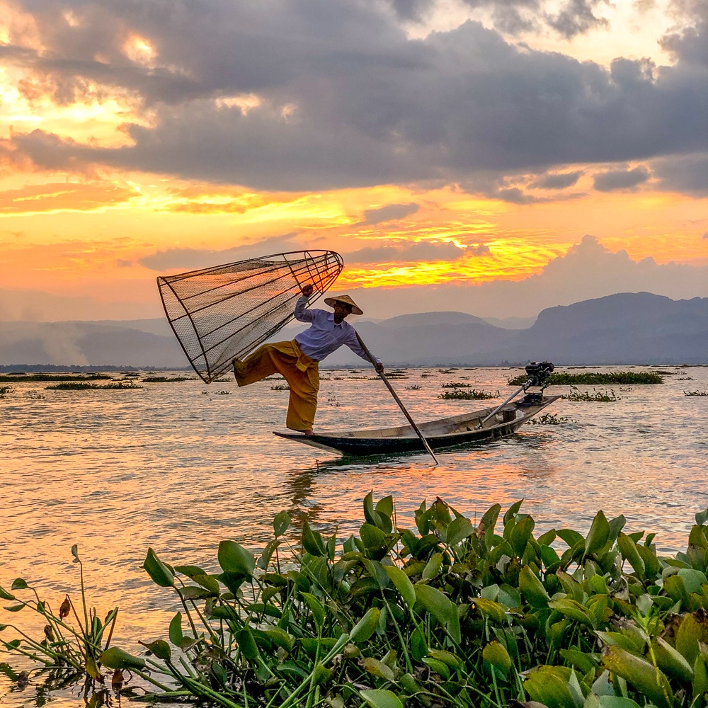 Intha Fisherman showing his stunts of one leg rowing technique at Inle lake, Myanmar. This is one of the best places to visit in southeast asia